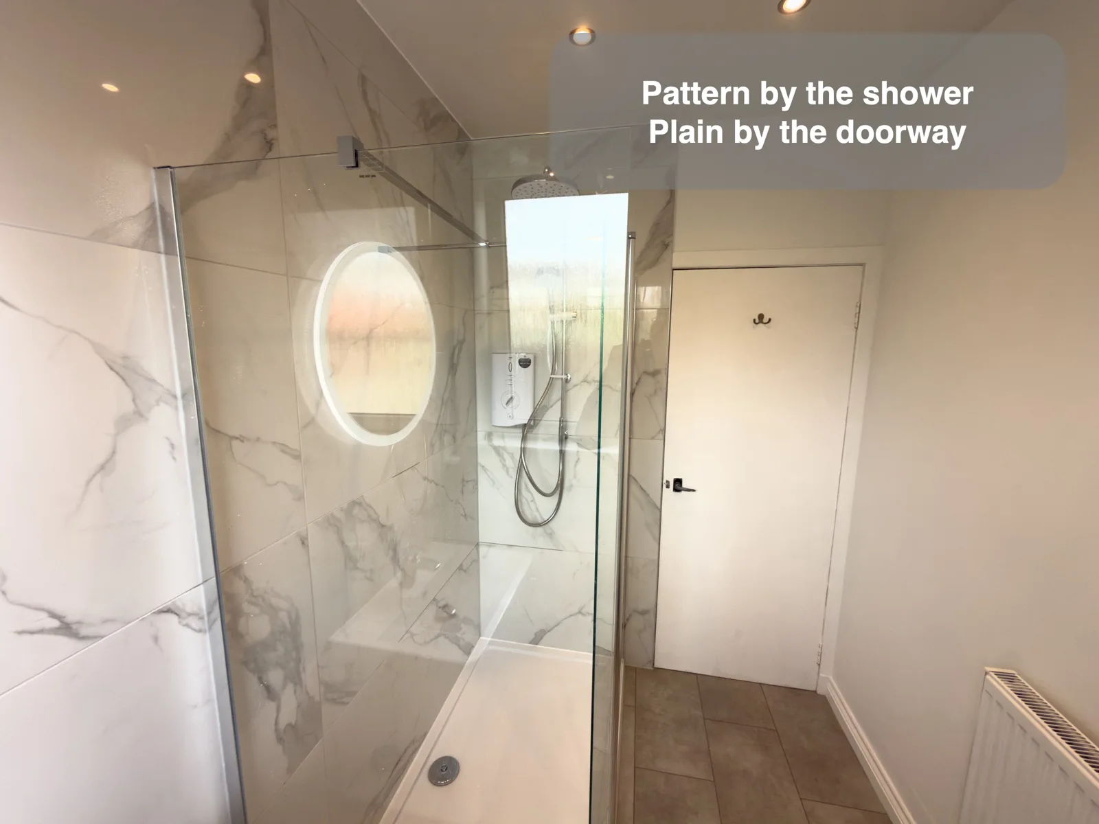Marble-effect shower/basin wall beside plain painted door/radiator wall.