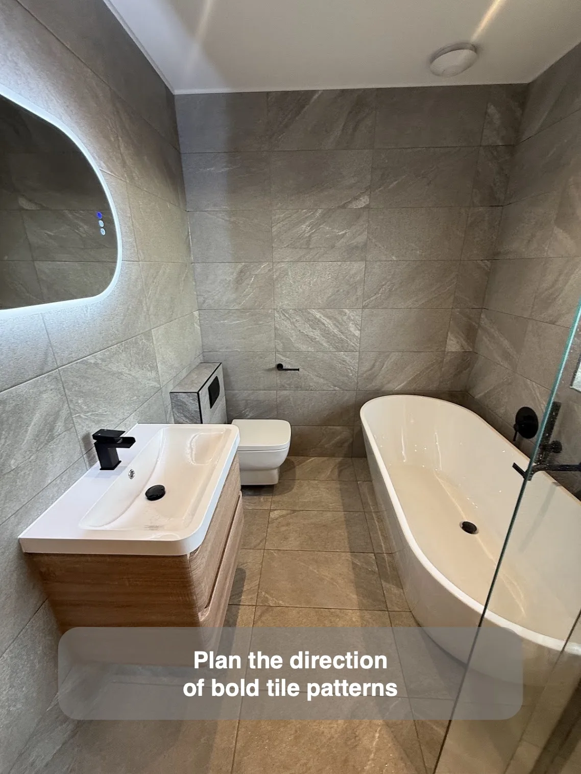 Diagonal stone-effect tile markings arranged across a bathroom end wall
