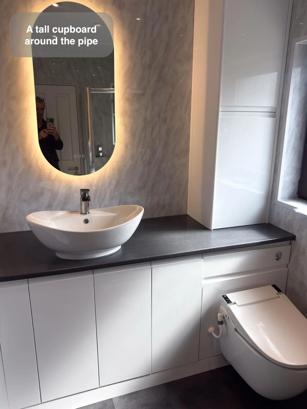 Put the vertical toilet pipe inside a useful cupboard