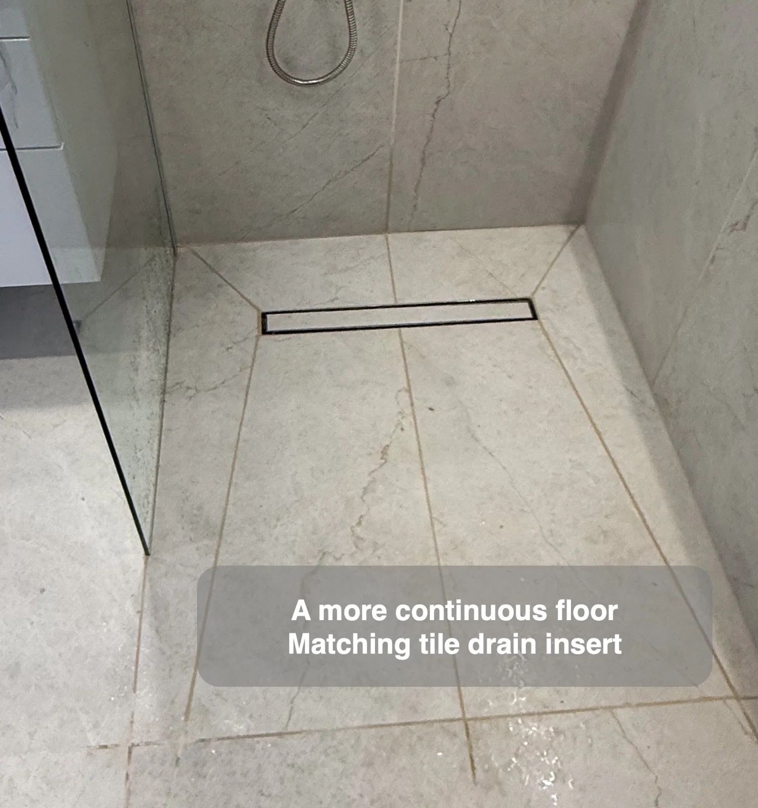 Tile insert linear shower drain within a grey tiled wetroom floor