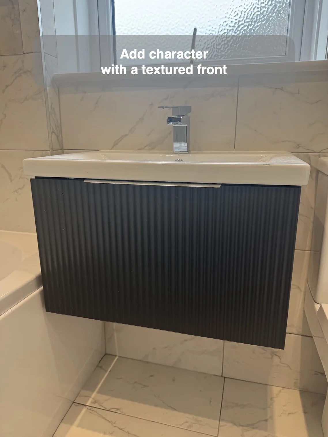 Dark ribbed wall-hung vanity front beneath a white basin