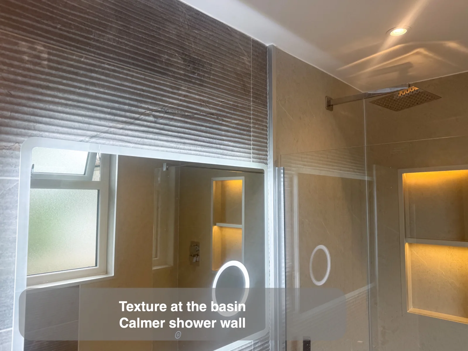 Ribbed horizontal mirror wall adjoining flat tiled shower wall.