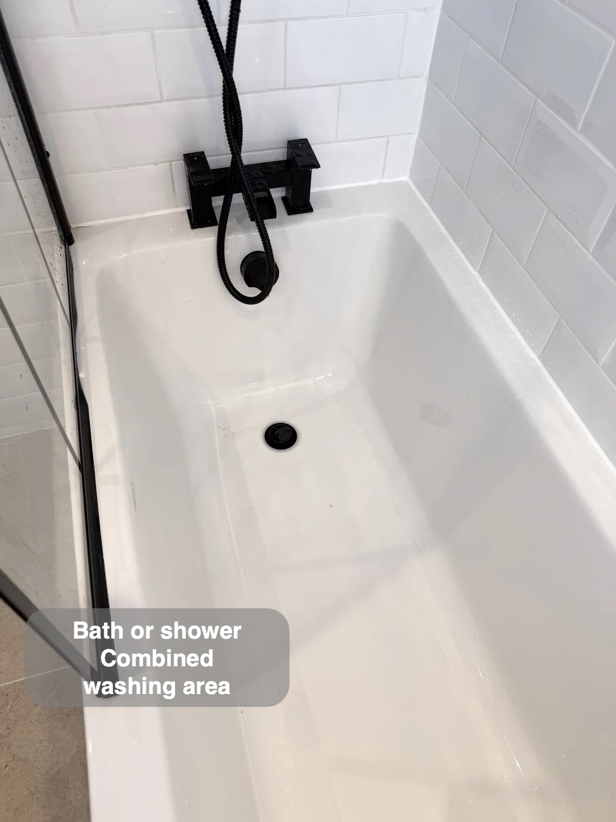 Bath beneath black shower handset