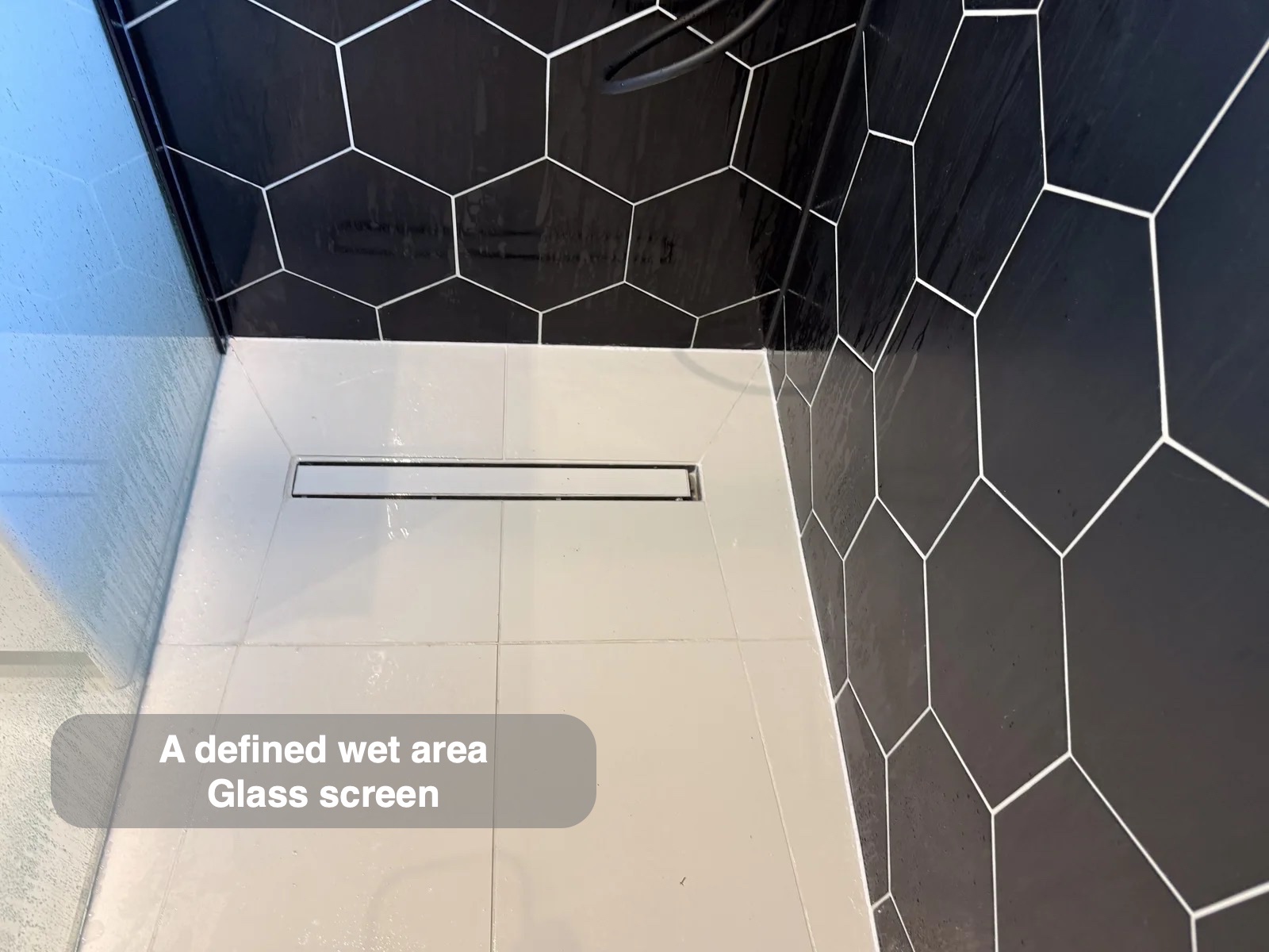 Wetroom floor with linear drain and glass panel