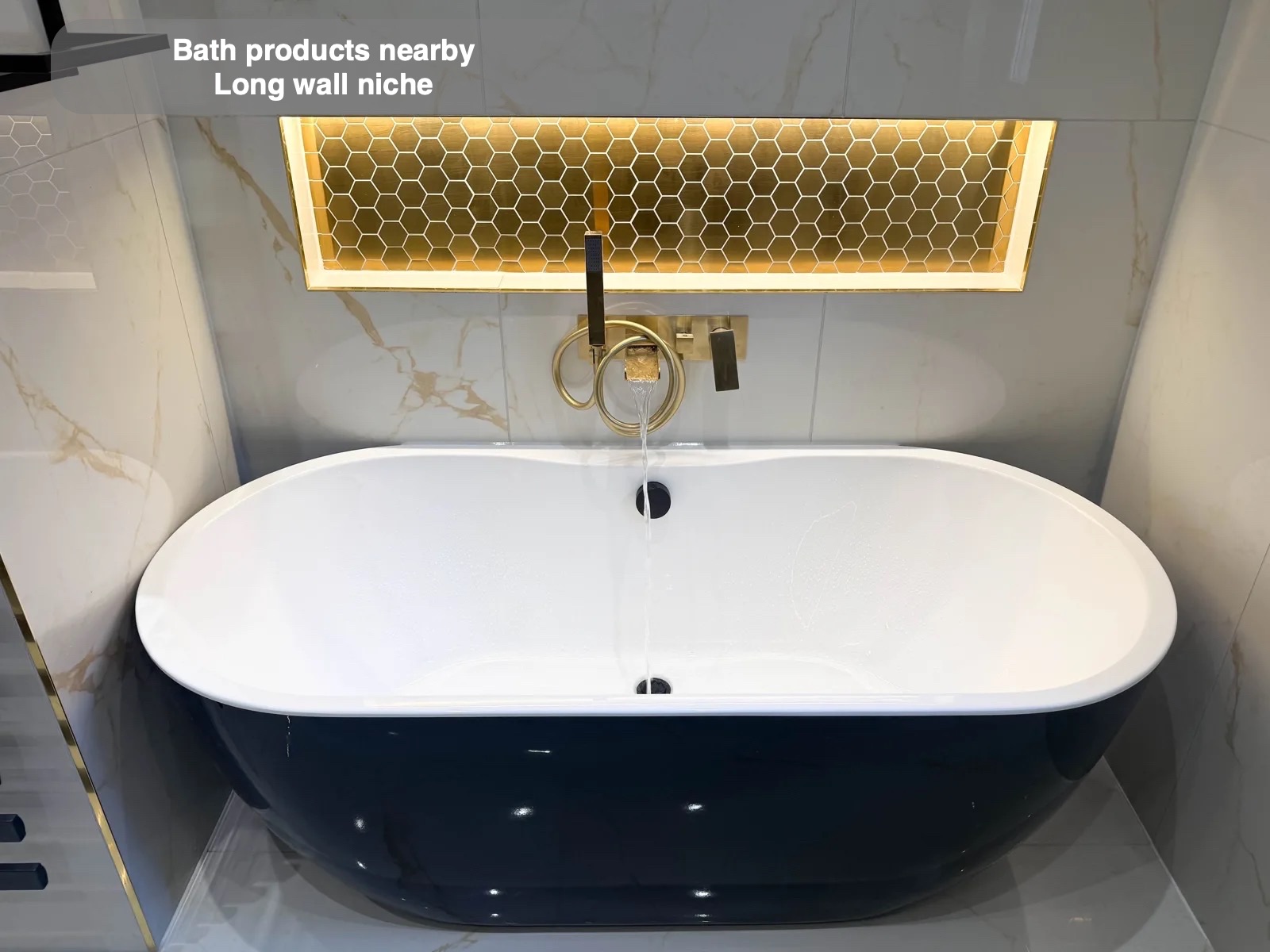 Black-exterior bath beneath illuminated mosaic niche