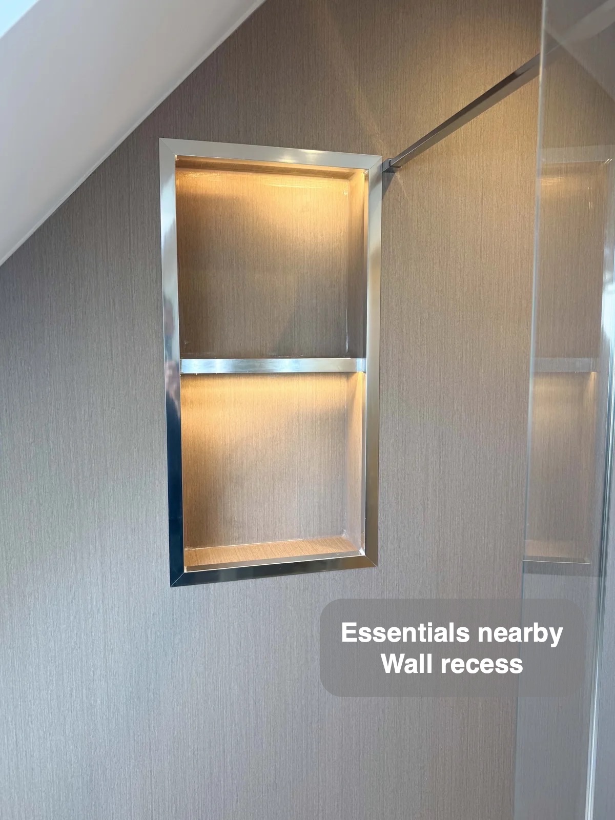 Illuminated shower recess beneath sloping ceiling