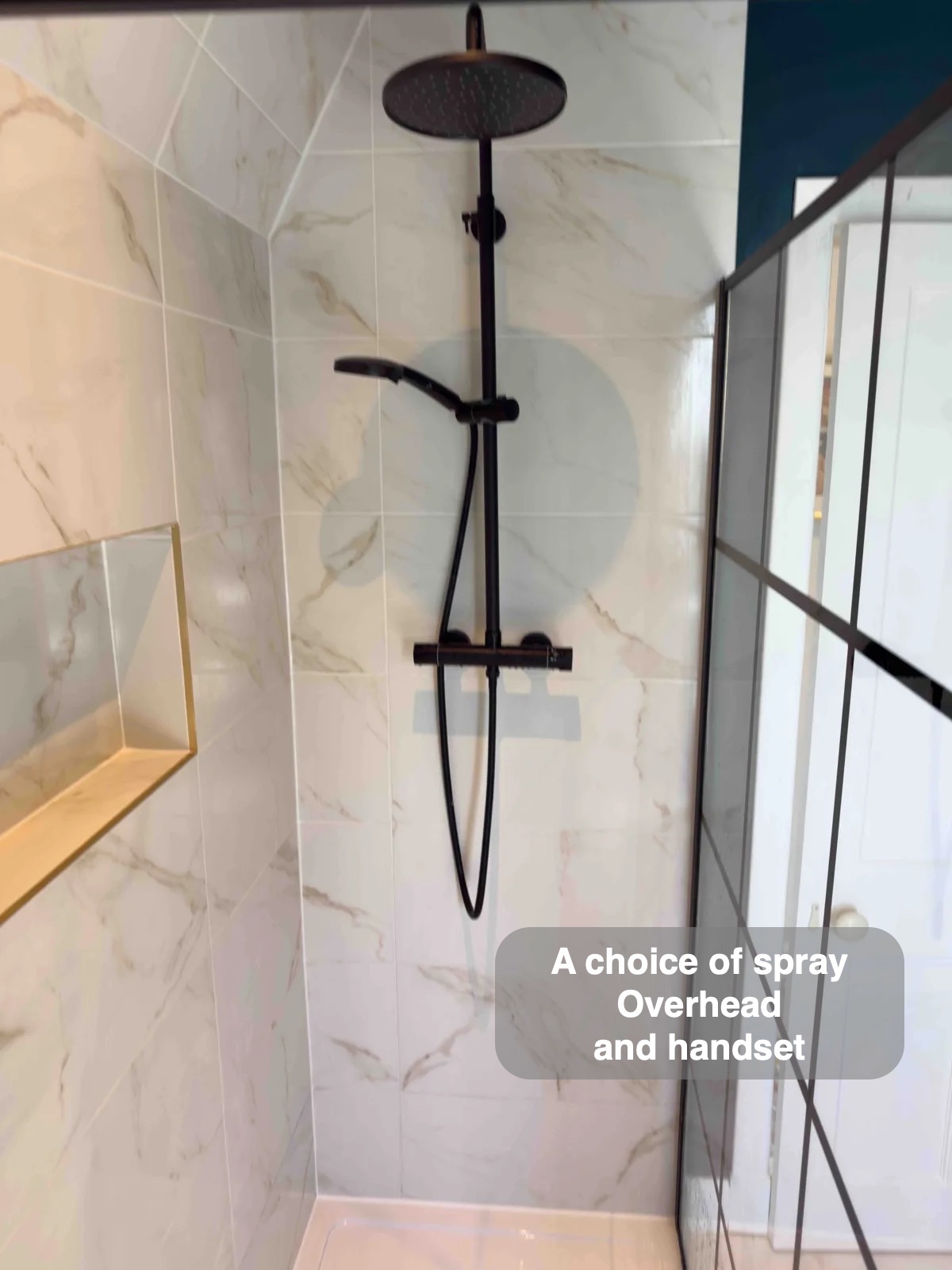 Black shower fittings beside recessed storage