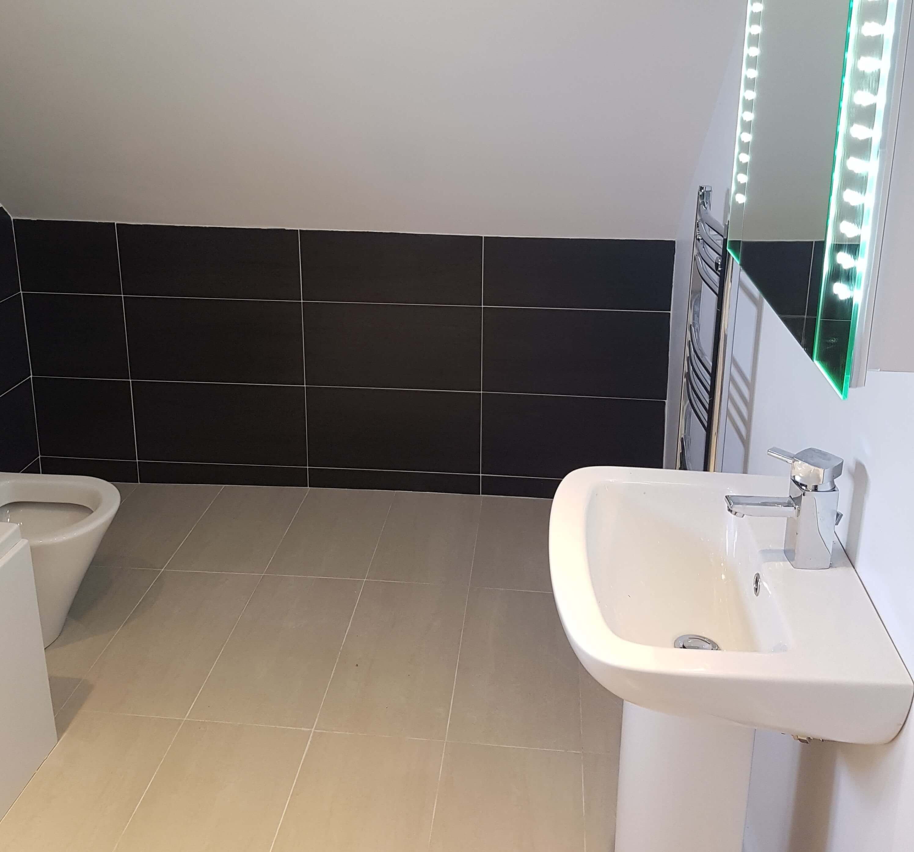 Sink and heated mirror. It can be seem some tiling in the background